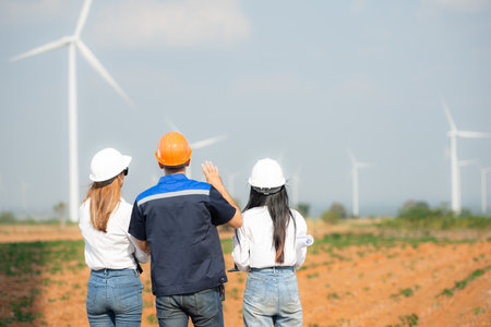 Team of engineers and architects working on wind turbines in a wind farmの写真素材