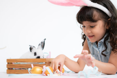 Smiling little girl and with their beloved fluffy rabbit, showcasing the beauty of friendship between humans and animalsの写真素材