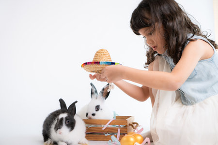 Smiling little girl and with their beloved fluffy rabbit, showcasing the beauty of friendship between humans and animalsの写真素材