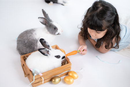 Smiling little girl and with their beloved fluffy rabbit, showcasing the beauty of friendship between humans and animalsの写真素材