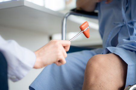 A doctor uses a reflex hammer to evaluate a patient's knee jointの写真素材