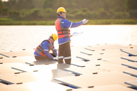 Photovoltaic engineers work on floating photovoltaics. Inspect and repair the solar panel equipment floating on the water.の写真素材
