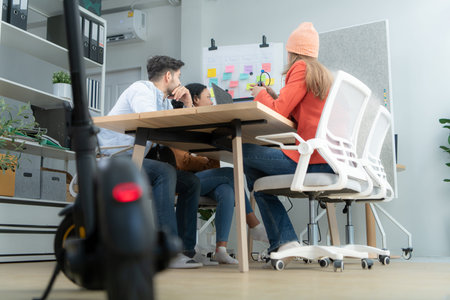 Selective focus of electric scooter in modern office with group meeting blurred background