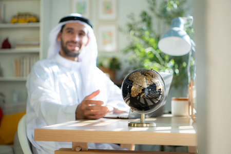 Portrait of young Arabic businessman working on laptop at homeの写真素材