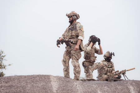 Soldiers in camouflage military uniforms carrying weapons, Reconnaissance missions in rugged...