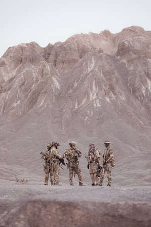 Soldiers in camouflage military uniforms carrying weapons, Reconnaissance missions in rugged mountains, Assault infantry battle training.の写真素材