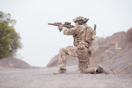Soldiers in camouflage military uniforms carrying weapons, Reconnaissance missions in rugged...