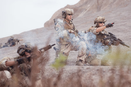 Soldiers in camouflage military uniforms carrying weapons, Reconnaissance missions in rugged...
