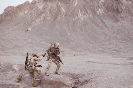 Soldiers in camouflage military uniforms carrying weapons, Reconnaissance missions in rugged mountains, Assault infantry battle training.の写真素材