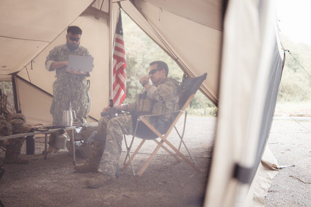 Group of soldiers in camouflage uniforms hold weapons in a field tent, Plan and prepare for combat...