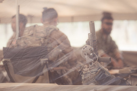 Group of soldiers in camouflage uniforms hold weapons in a field tent, Plan and prepare for combat training.の写真素材