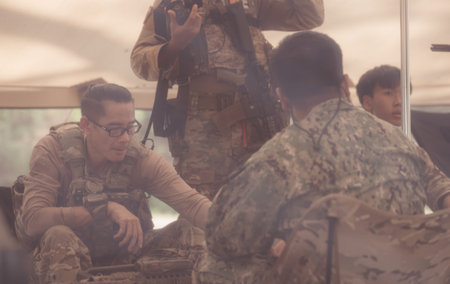 Group of soldiers in camouflage uniforms hold weapons in a field tent, Plan and prepare for combat training.の写真素材