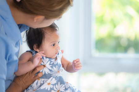 A mother plays with her little daughter in a bedroom full of warmth and family.