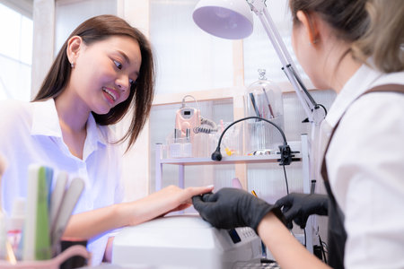 A nail technician is painting the nails of a customer.の写真素材