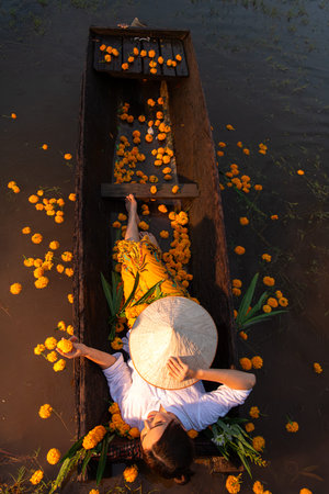 Young woman on a boat with yellow flowers in the lake during the sunset