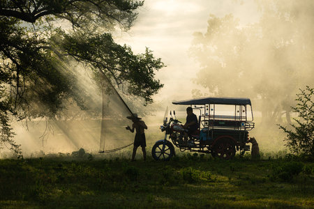Local fisherman prepare a fishnet under the tree to capture fish in the lakeの写真素材
