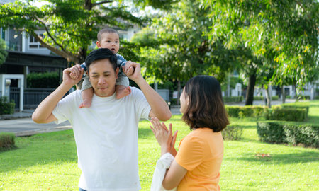 Parents with little child are having fun and resting in a parkの写真素材