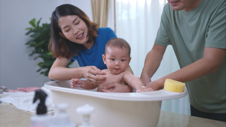 Parents bathe little child after ate mealの写真素材