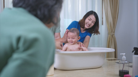 Parents bathe little child after ate meal with grandmotherの写真素材