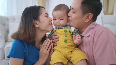 Parents and their little child play happily in the living room of the houseの写真素材