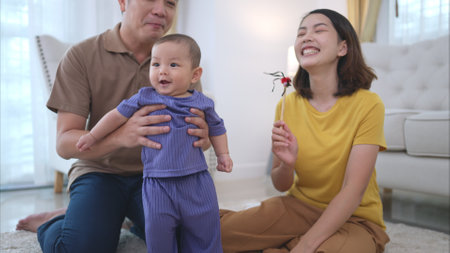 Parents and their little child play happily in the living room of the houseの写真素材