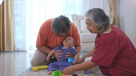 Grandparents and their little grandchild play happily in the living room of the houseの写真素材