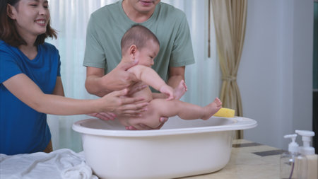 Parents bathe little child after ate mealの写真素材