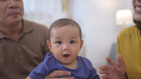 Parents and their little child play happily in the living room of the house