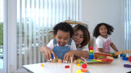 On a holiday, A woman and her two little daughters sit on the floor and play the toy togetherの写真素材
