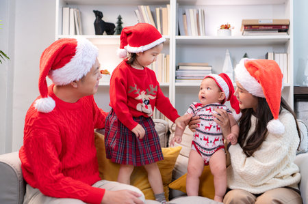 Parents and their two children are dressed in Christmas outfits to celebrate the Christmas holiday...