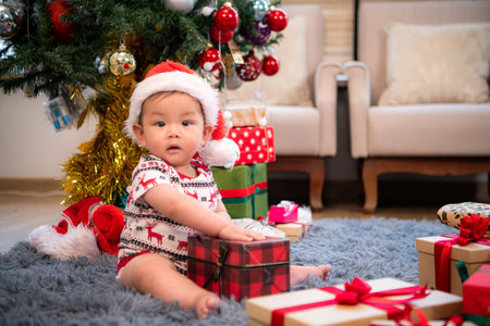 A little child in a Christmas outfit is celebrating the Christmas holiday with their family at homeの写真素材