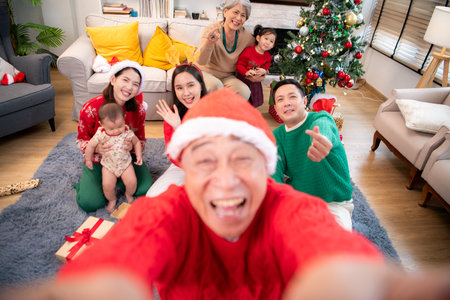 A joyful moment for a large family celebrating together at home during the Christmas seasonの写真素材