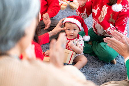 Little child with a joyful moment for a large family celebrating together at home during the Christmas seasonの写真素材