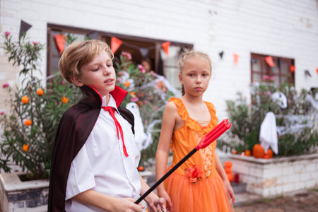 Children in ghost costumes are having fun trick-or-treating on Halloweenの写真素材