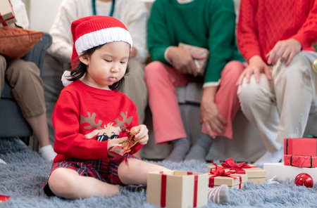 Little child with a joyful moment for a large family celebrating together at home during the Christmas seasonの写真素材