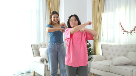 Two sister enjoys dancing together at home during the holidaysの写真素材