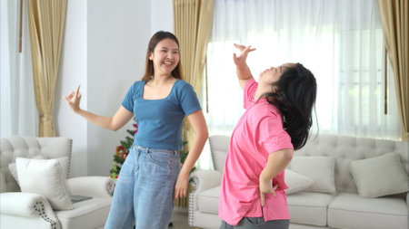 Two sister enjoys dancing together at home during the holidaysの写真素材