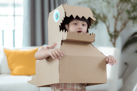 A special child with his favorite dinosaur figure, having fun in the living room of the houseの写真素材