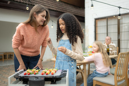 Grandfather, parents, and the teenage girls are all having dinner together at homeの写真素材