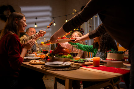 Grandfather, parents, and the teenage girls are all having dinner together at home on Christmas nightの写真素材