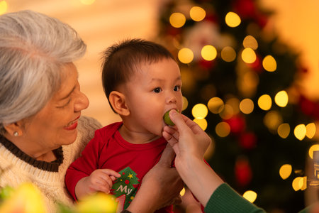 Grandmother, mother and little boy celebrate happily on Christmas nightの写真素材