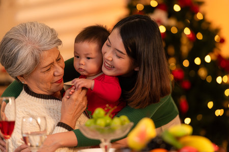 Grandmother, mother and little boy celebrate happily on Christmas nightの写真素材