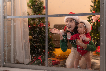 Mother and son relax on a snowy Christmas nightの写真素材