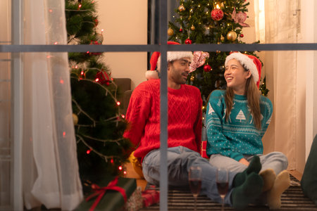 Couples relax, drink and celebrate on a snowy Christmas nightの写真素材