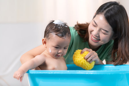 When mom gives the baby a bath, he enjoys itの写真素材