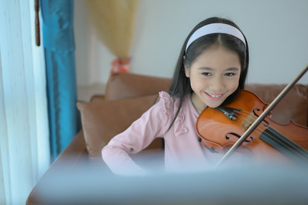 A girl violinist plays and practices the violin at homeの写真素材
