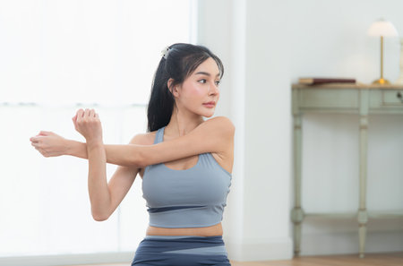 Asian young women doing yoga exercises during their holiday at homeの写真素材