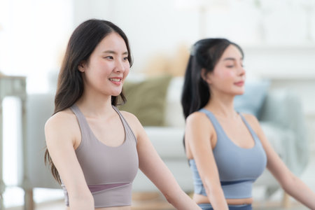 Asian young women doing yoga exercises during their holiday at homeの写真素材