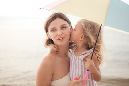 Mother and daughter relaxing on the beachの写真素材
