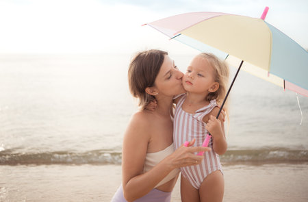 Mother and daughter relaxing on the beachの写真素材